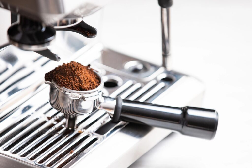 Coffee beans in a portafilter by the coffee grinder