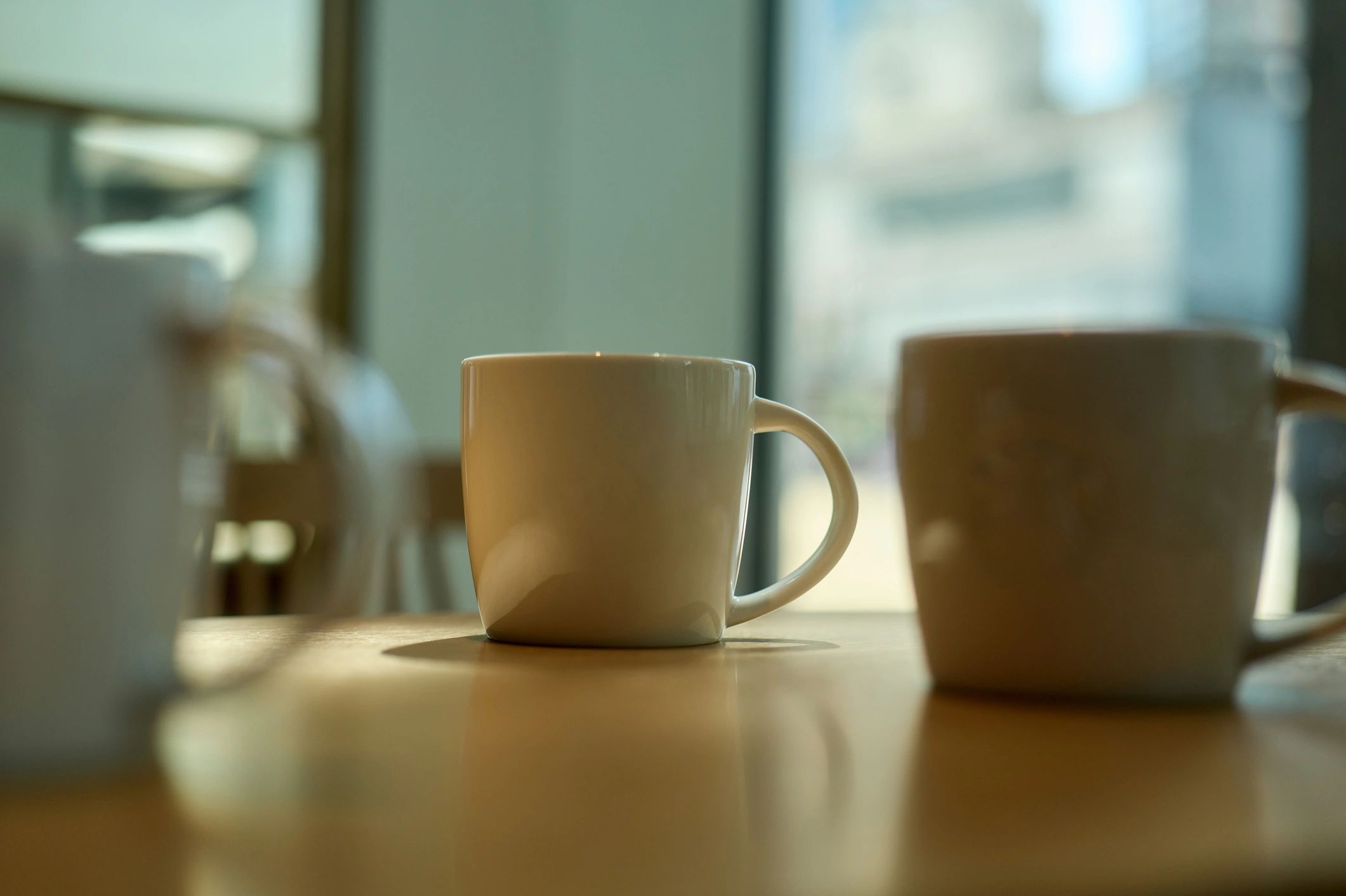 Empty coffee cups on a table near a window