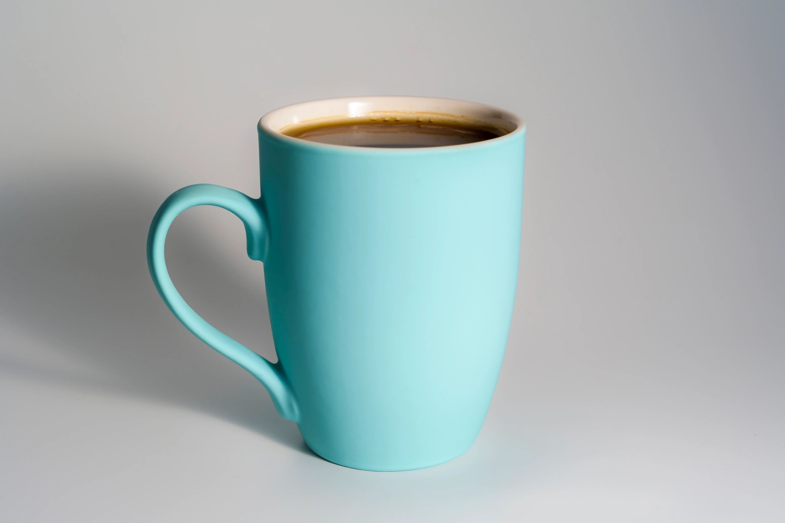 Turquoise ceramic mug filled with coffee